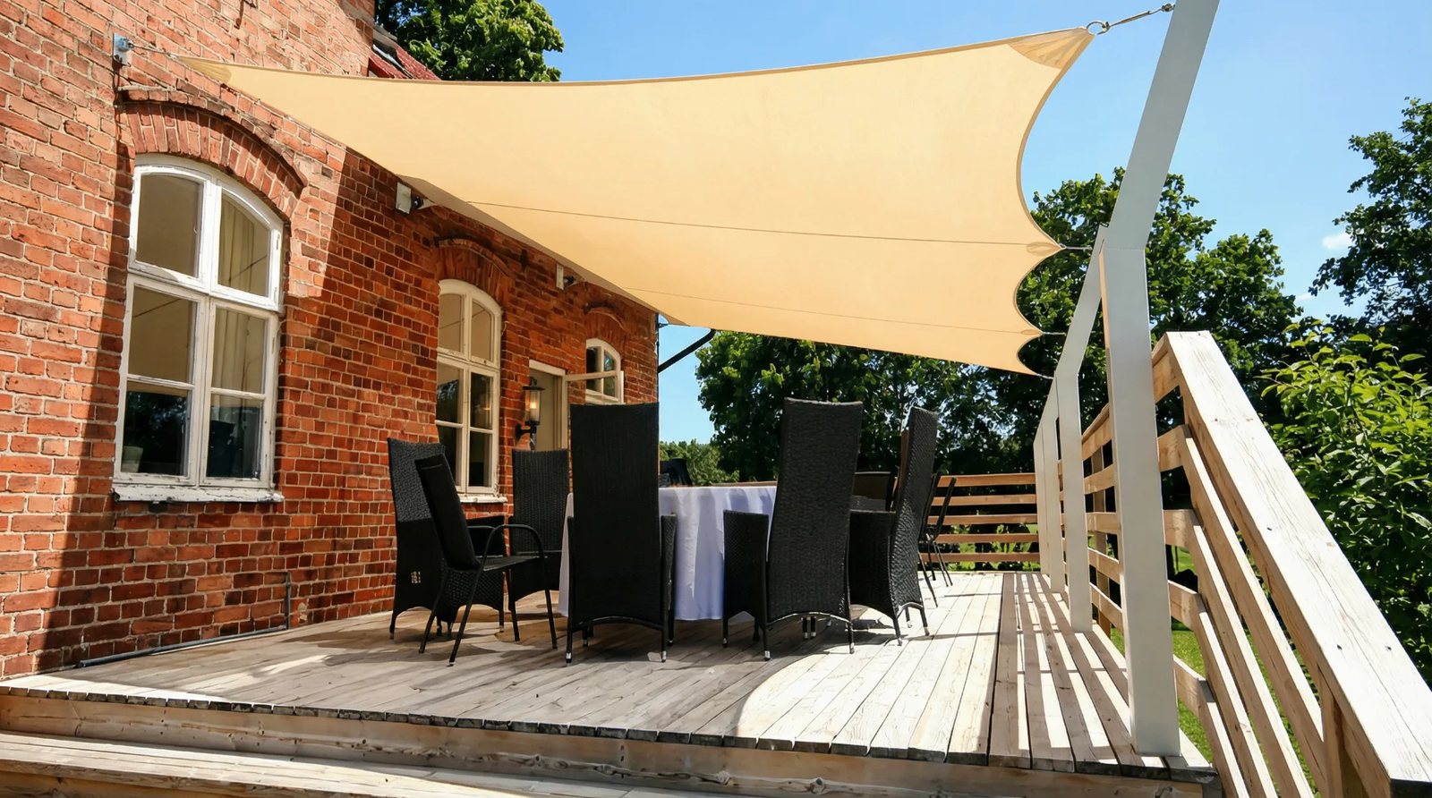 Beige solsegel över uteplats vid tegelhus