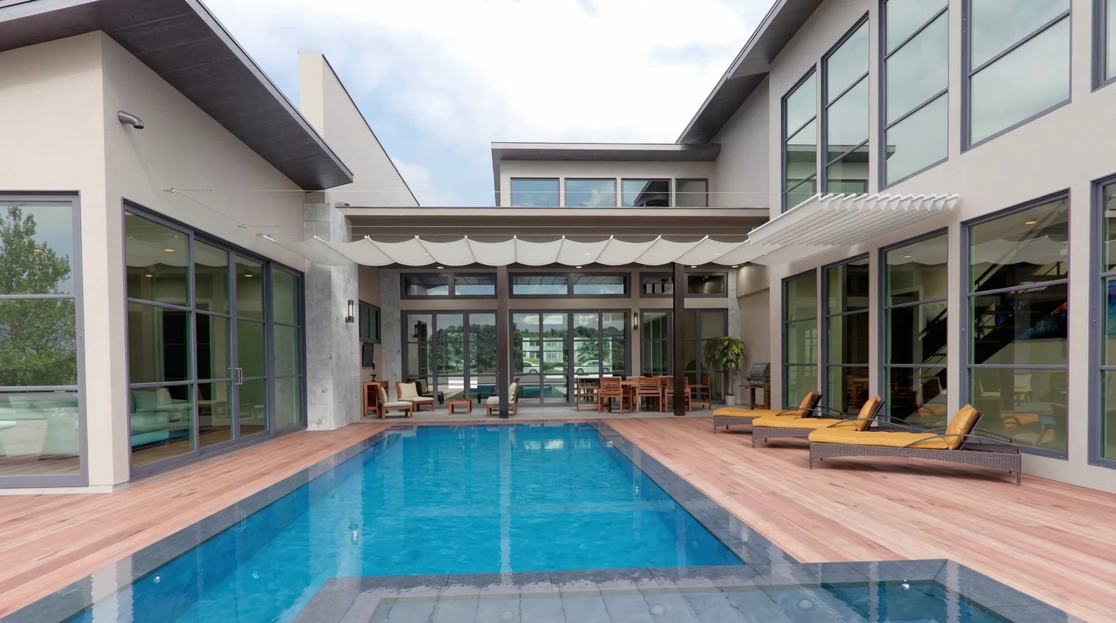 Vajersolskydd över stor pool vid modern villa